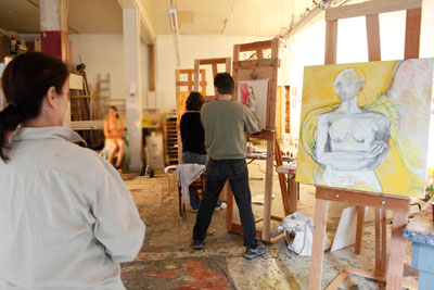 Students painting from a live figure model in class